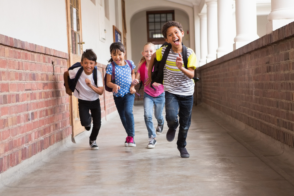 Cute pupils running down the hall at the elementary school Cute pupils running down the hall at the elementary school