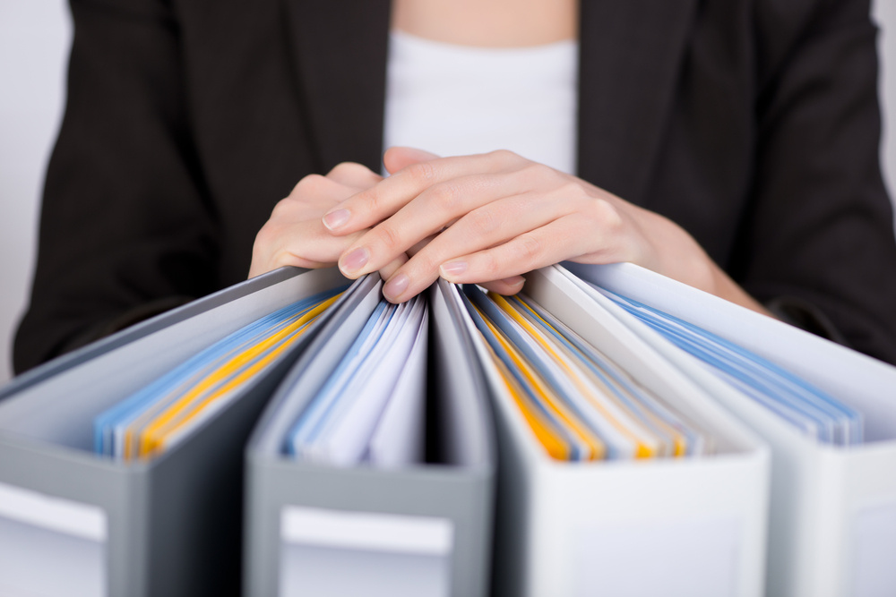Midsection of businesswoman with binders at office Midsection of businesswoman with binders at office